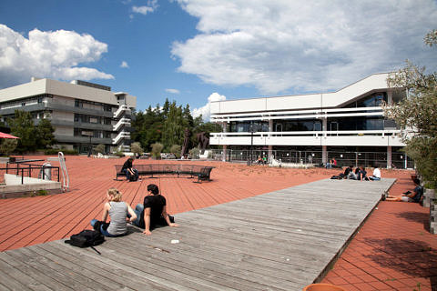 Studierende sitzen auf dem roten Platz der TechFak