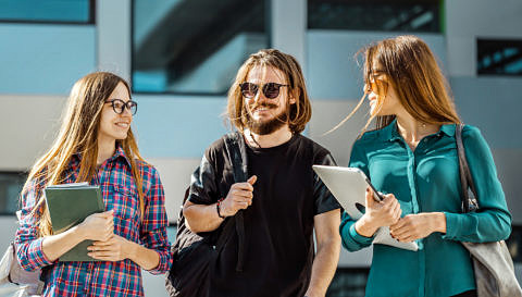 Studierende unterhalten sich vor einem Gebäude